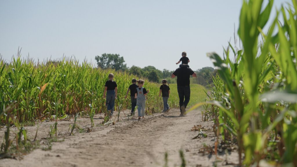 Father walking with his children at farm.